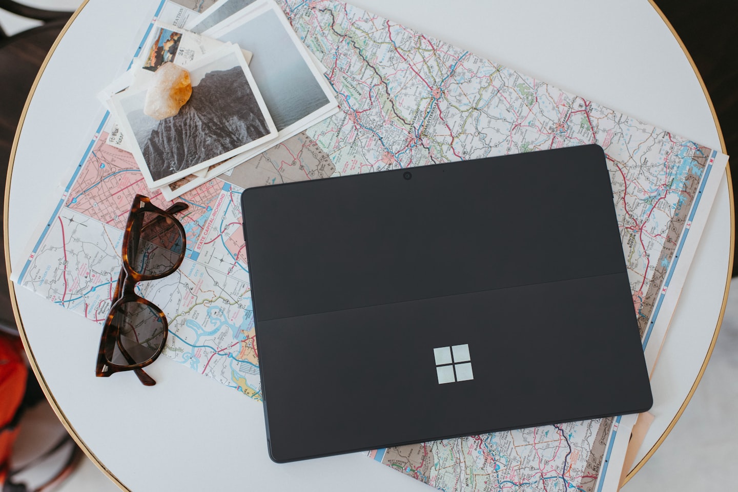 Computer portatile e oggetti da viaggio disposti su una mappa per pianificare un viaggio.